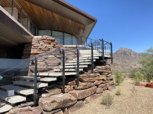 Frameless glass railing wrapping around the side of a home