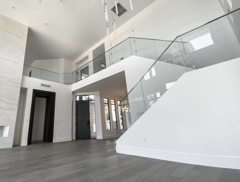 Glass railing on stairs from the main level of a house to the upstairs