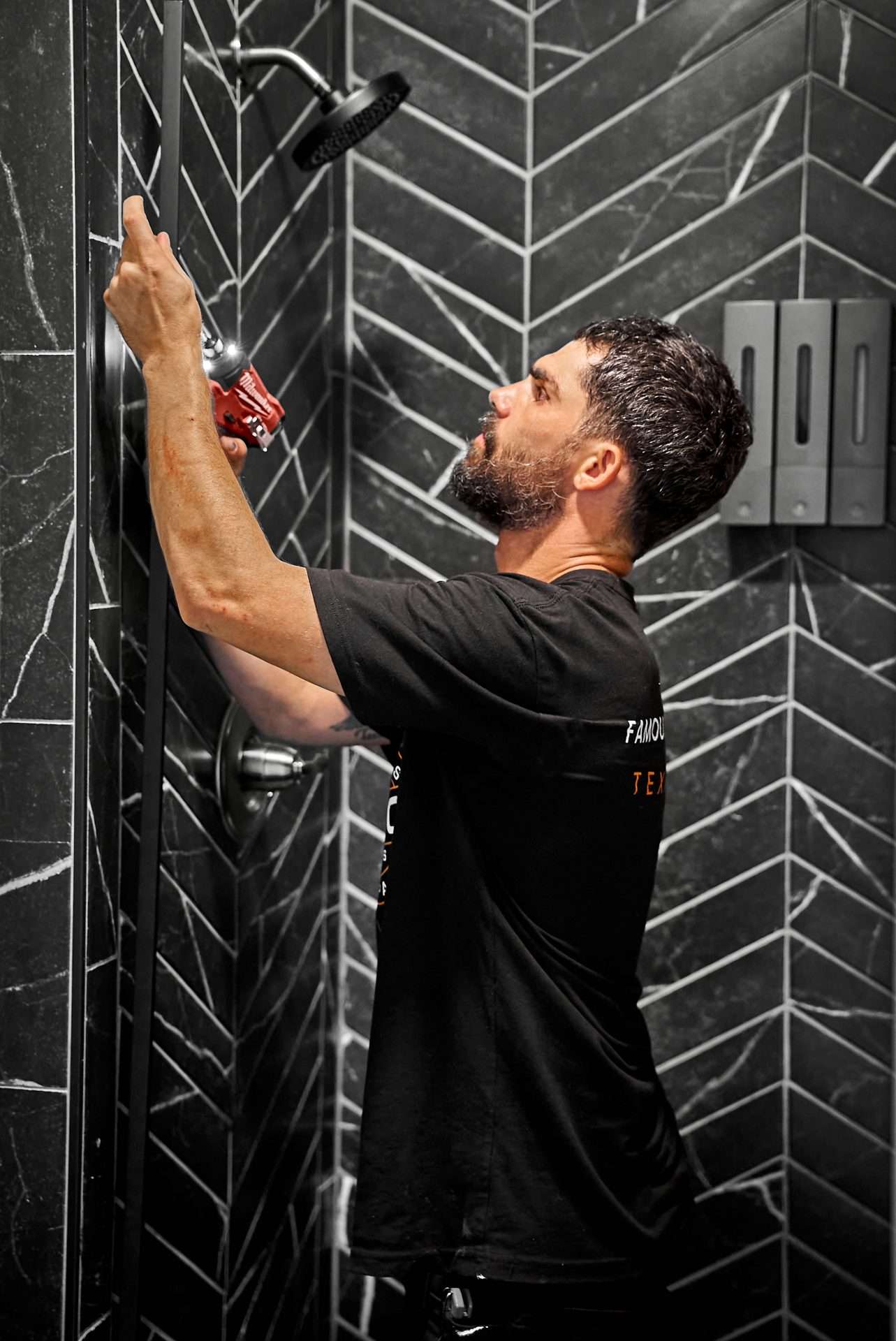 worker installing a shower head